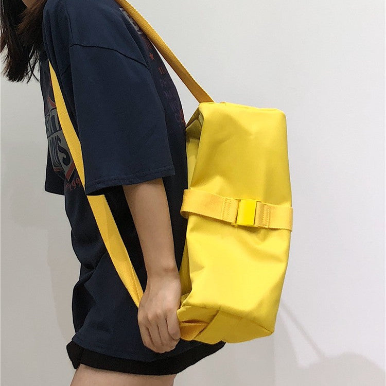 Person holding a yellow bag against a plain background