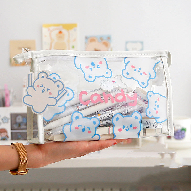 Clear pouch with cartoon designs holding stationery items, held by a person.