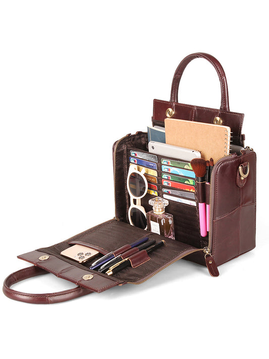 Brown leather handbag with various compartments and items on a white background