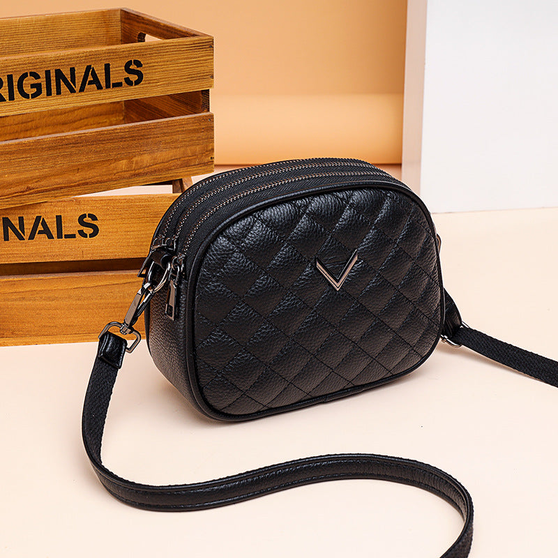 Black quilted handbag on a light background with 'ORIGINALS' wooden crate in the background.