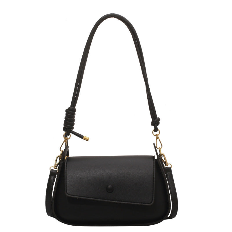 Black handbag with a braided handle on a white background