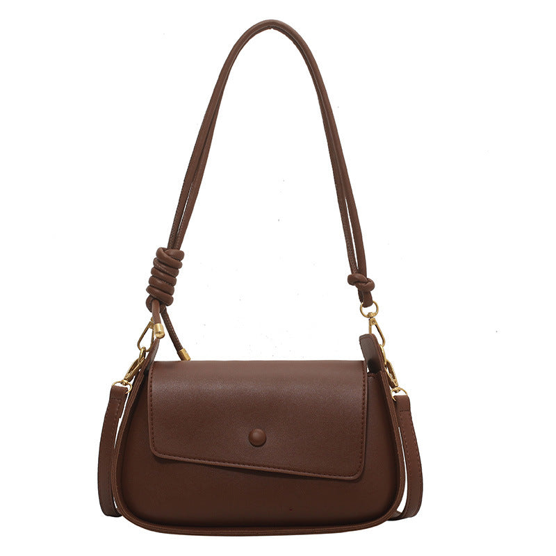 Brown handbag with a knotted strap on a white background