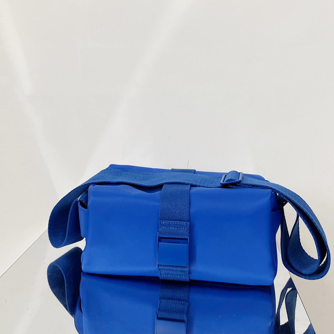 Blue bag with a strap on a reflective surface