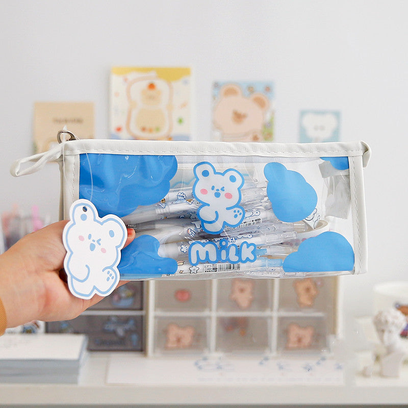 Clear pouch with blue bear design held by a hand, with a blurred background of shelves.