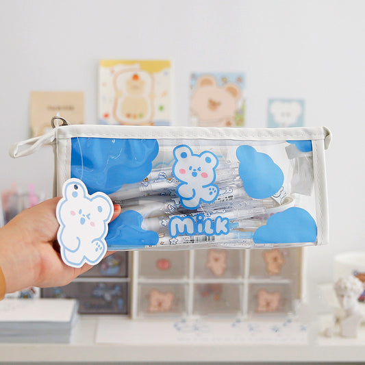 Clear pouch with blue bear design held by a hand, with a blurred background of shelves.