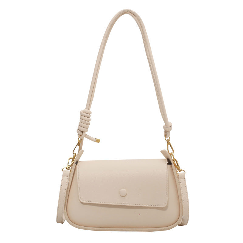 Beige handbag with a rope handle on a white background