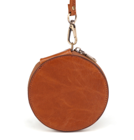 Brown round leather bag with a strap on a white background