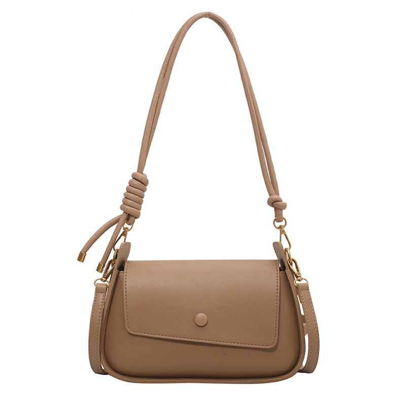 Beige handbag with a shoulder strap on a white background