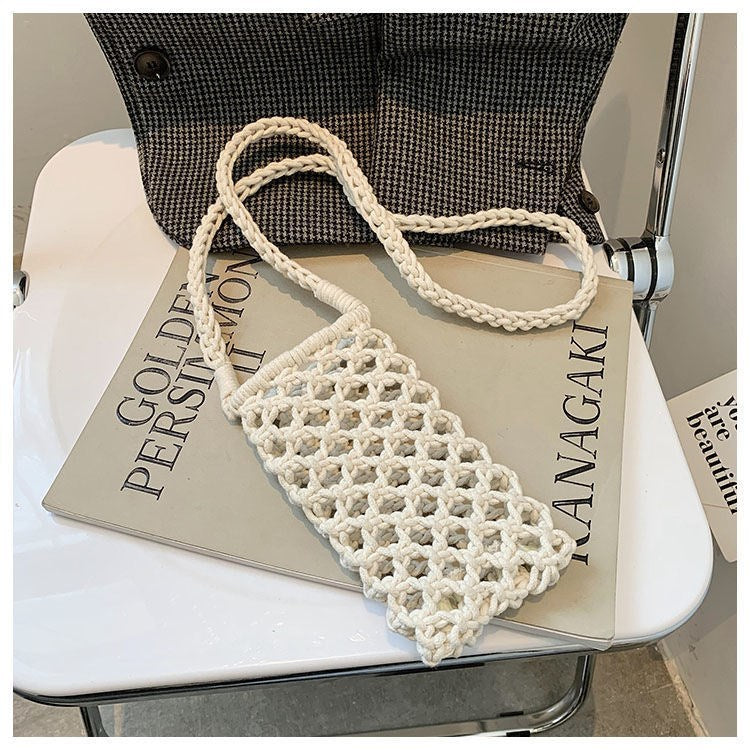 White woven handbag on a magazine with a chair in the background