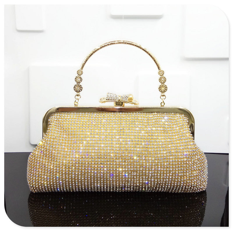 Gold handbag with rhinestone embellishments on a white background